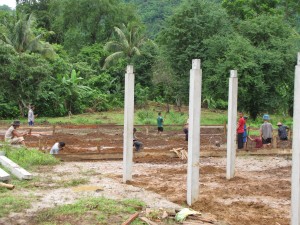 A closer look at the boy's dorm site. The workers in the background are digging holes for more cement post for the boy's bath house.