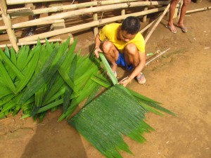 Making leaf panels for the bathroom walls and roof. These panels are made out of some kind of palm tree.