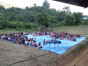 Everybody sitting on tarps in front of the boys dorm.